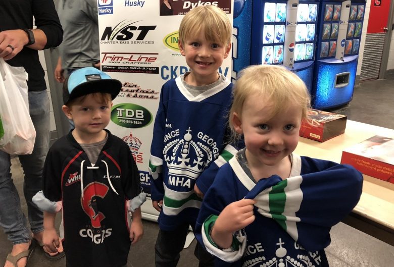 three kids in hockey jerseys