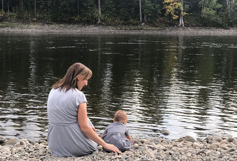 Mom and daughter sitting by the Nechako River