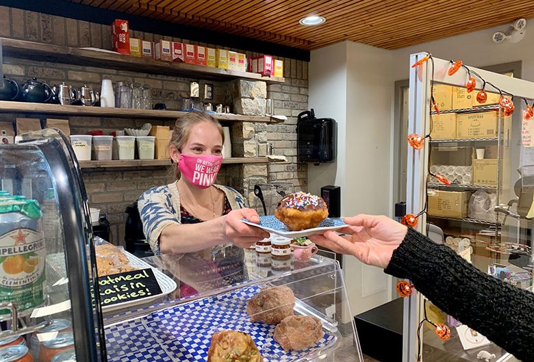 Woman handing over a bannock doughnut.