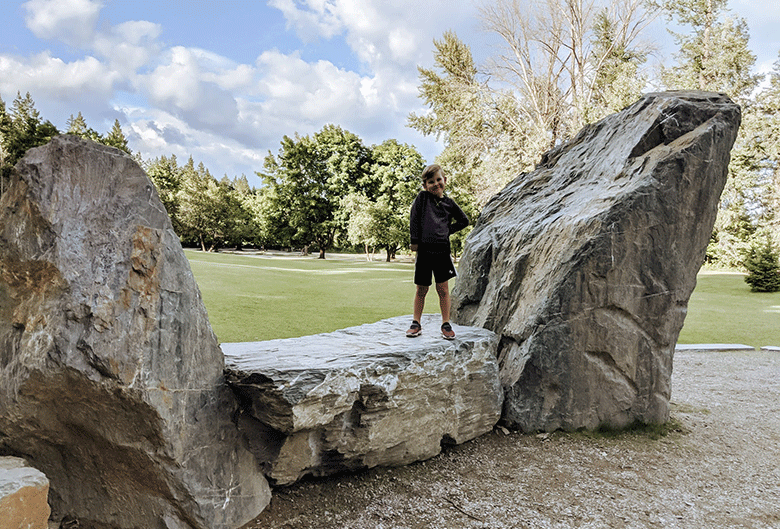Boy standing on rock.