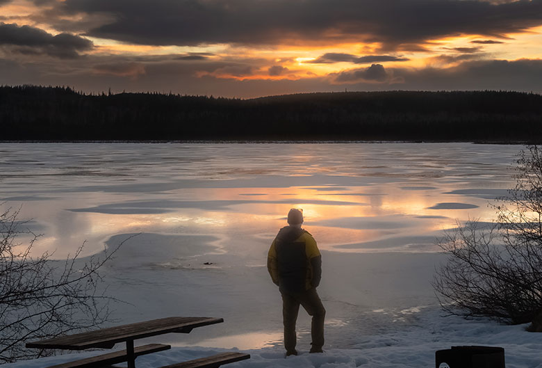Man standing in front of winter sunset
