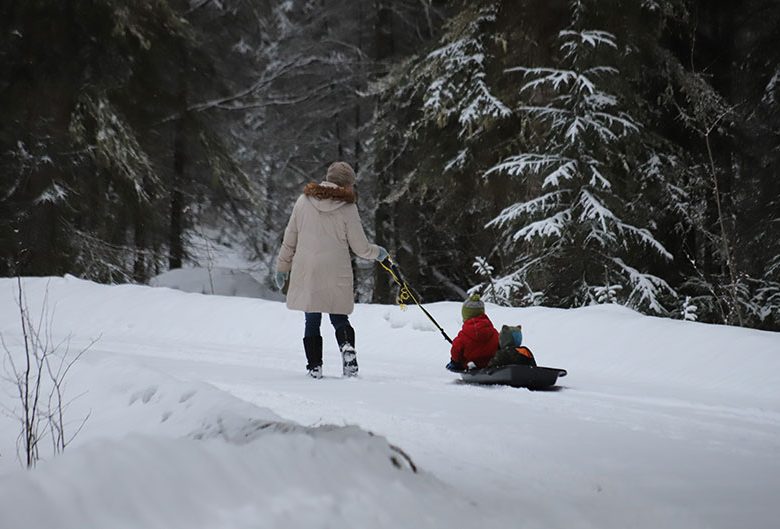 woman pulling sled in snow